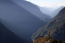 朝日の中ヒマラヤの山間を飛ぶ小型飛行機