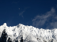 白い月と雪に覆われた八ヶ岳