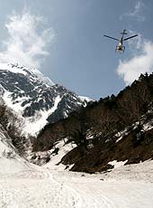 北アルプスの山間を飛ぶヘリコプター