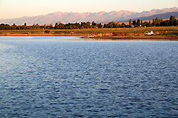 朝焼けのキルギスのイシク・クル湖と天山山脈