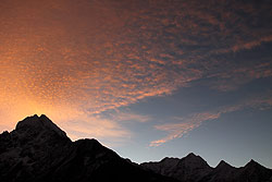 朝焼けに赤く染まるヒマラヤの空とエベレスト山群