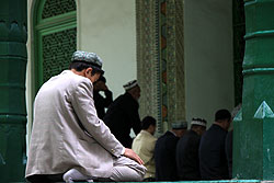 モスクでお祈りする男性